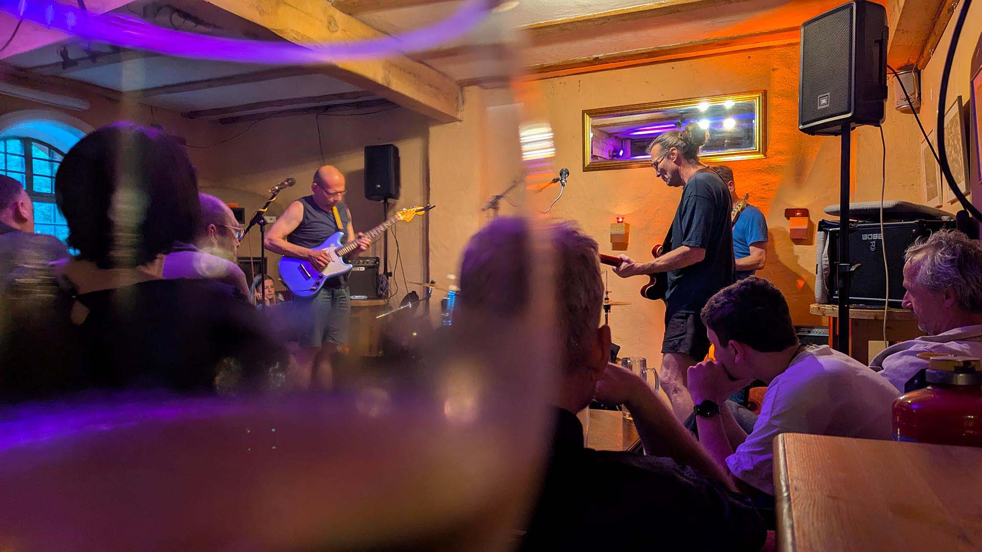 Die Band Stereopark spielt im Café des Ökospeichers. Im Vordergrund Besucher.